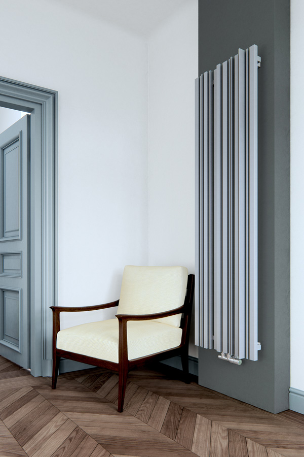 Designheizkörper Sherwood V arrangiert in Grau Frontal in Wohnzimmer neben Sessel